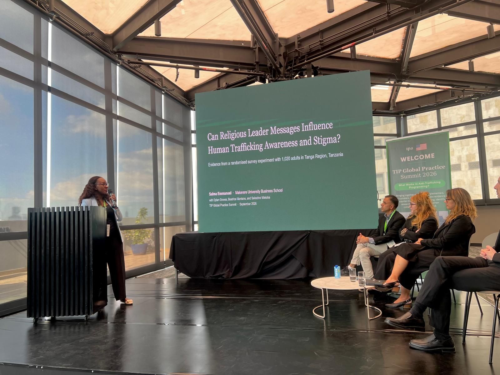 Salma Emmanuel speaks at a podium beside her title slide at the TIP Global Practice Summit in Mexico City, with fellow panelists seated on stage